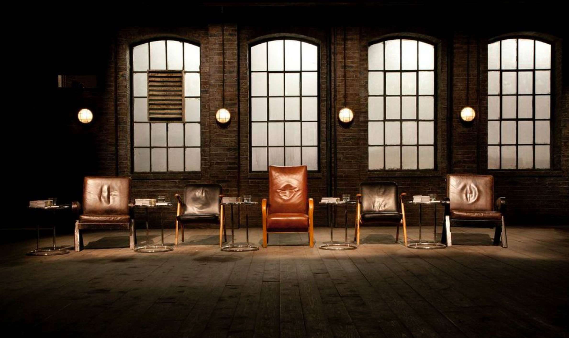 The empty Dragon's Den chairs — five leather seats lined up against warehouse windows, waiting for the next pitch